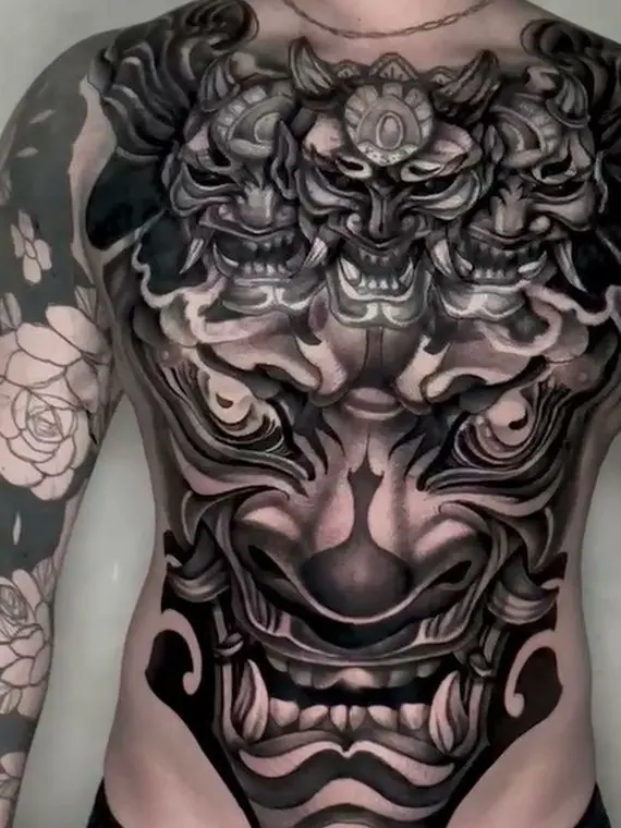 Después: el torso completo terminado en black and grey, con los demonios rehechos