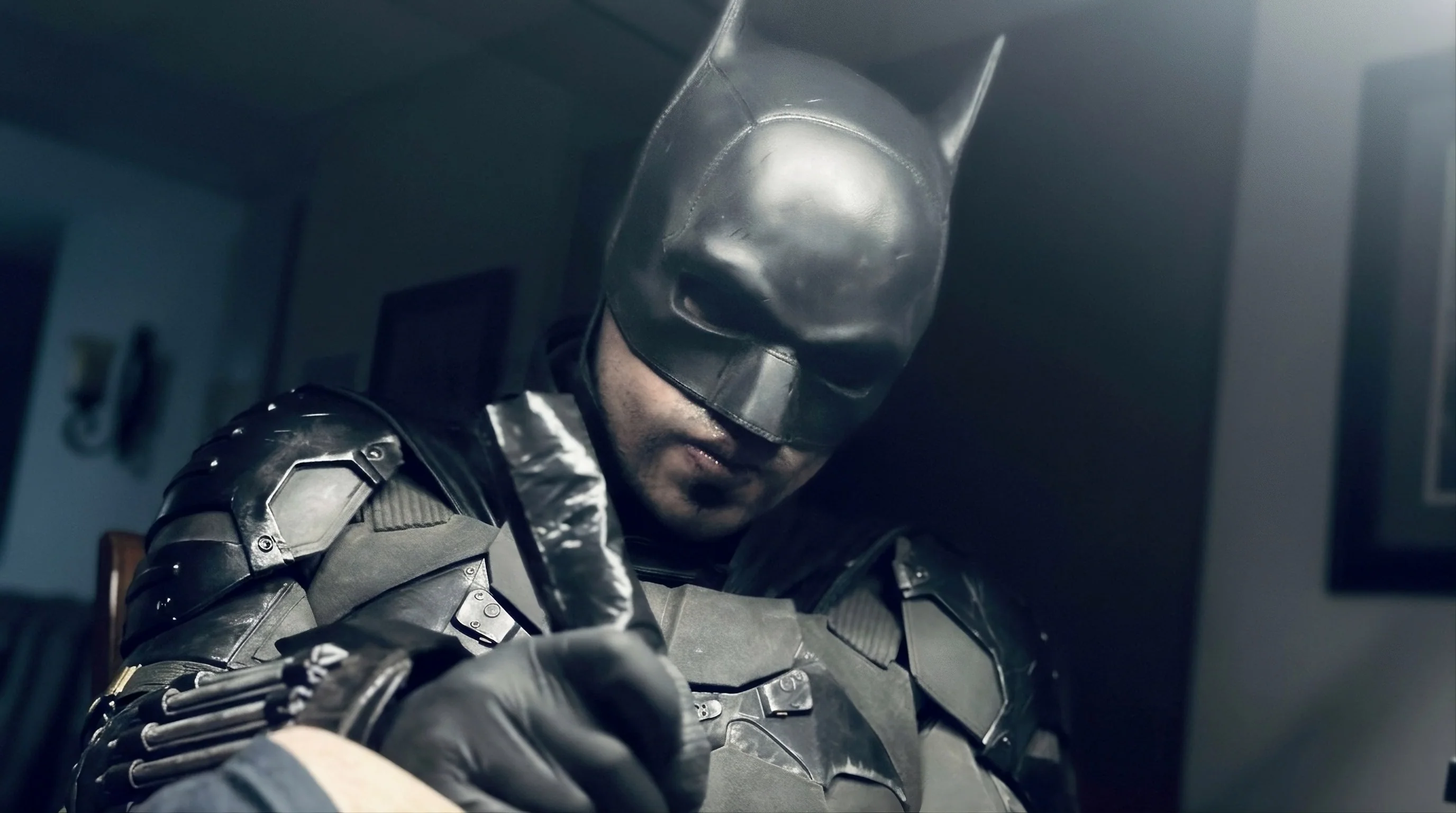 Edd Arrows con su traje negro y máscara, tatuando en el estudio